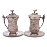 A pair of Egyptian silver mugs, covers and saucers: of waisted form,