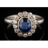 A sapphire and diamond oval cluster ring: the oval sapphire approximately 7.5mm long x 6.