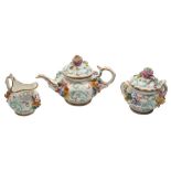 A mid 19th century English miniature flower encrusted part tea service: applied with floral sprays