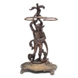 A bronze umbrella stand: the backplate cast as a male peasant in 18th century attire,