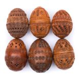 A collection of six carved egg-shaped coquilla nut pomanders: with concentric ringed,