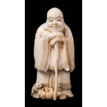 A Japanese ivory okimono of Hotei, signed Gyokugetsu: the smiling god leaning on his staff,