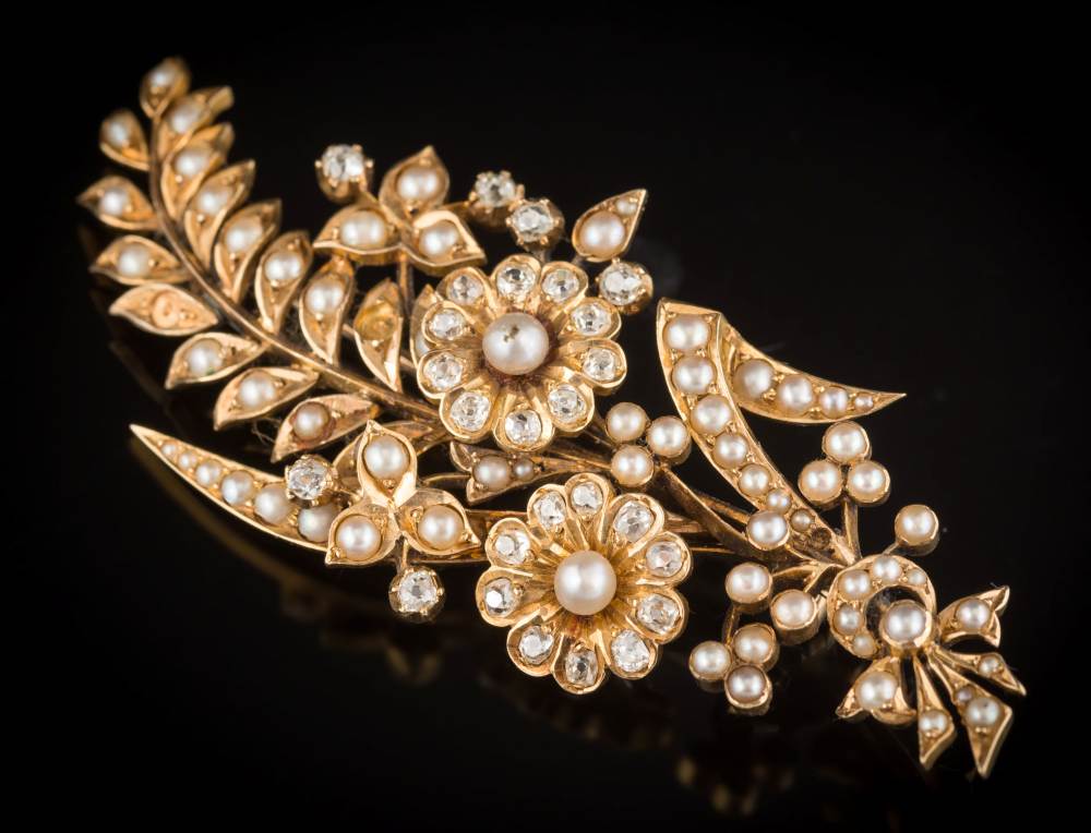 A late 19th century diamond and split seed-pearl floral spray brooch: with two principal flower