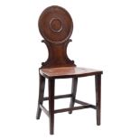 A George III mahogany hall chair:, the circular moulded panel back with C-scroll uprights,