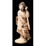 A Japanese carved ivory okimono of a bijin: wearing traditional Kimono adjusting her hair with her