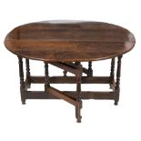 A George I oak gateleg table:, on an oval hinged top, on turned baluster legs,