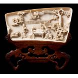 A Chinese carved ivory calligrapher's wrist rest: of rectangular outline,