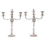 A pair of Victorian silver plated twin-branch candelabra: the urn shaped nozzles with foliate