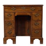 A George III mahogany kneehole desk:, the top with a moulded edge and rounded corners,