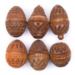 A collection of six carved egg-shaped coquilla nut pomanders: with concentric ringed,