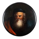 A 19th century papier mache snuff box: the circular lid decorated with a portrait of a bearded