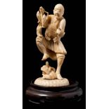 A Japanese carved ivory okimono of a fisherman: urprised by a snake emerging from a rock,
