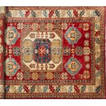 A Kasak rug:, the square ivory central field with hooked motifs,