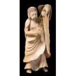 A Japanese carved ivory okimono: depicting a monk protecting a dove from an eagle,
