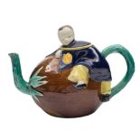 A Joseph Holdcroft majolica teapot and cover: modelled as a Chinese boy clambering onto a coconut