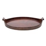 An 18th century mahogany and brass bound oval twin handled tray: with scroll handles to the sides,