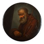 A 19th century papier mache snuff box: the circular lid decorated with a portrait of a monk with