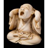 A Japanese carved ivory okimono of a yawning man, signed Yoshiyuki: seated cross-legged,