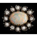 An opal and diamond mounted oval cluster flower brooch: with central oval opal approximately 17mm x