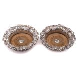 A pair of silver plated wine coasters: of circular outline with grape and vine leaf decorated