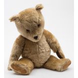 A blonde plush Teddy bear:, with glass eyes ,