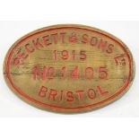 An oval brass worksplate Pecket & Son Ltd, Bristol No 1405, 1915:, red filled text, 31cm long.