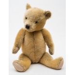 A golden plush Teddy bear:, with glass eyes,
