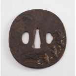 A 19th century Japanese iron tsuba:, with relief decoration of figures on a mountain path,