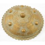A 19th century Persian brass dhal:, with six raised bosses and floral pattern star decoration,