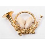 A hunting brooch in the form of a bugle:, comprising two stag teeth, the reverse stamped '750',