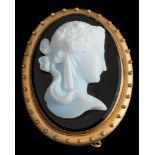 An oval glass cameo portrait brooch: with white glass portrait of a young woman on a black glass
