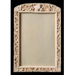 A Canton ivory rectangular frame: carved with a vacant cartouche and a continuous band of flowers