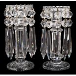 A pair of cut glass table lustres: with circular star cut bases supporting an octagonal column and