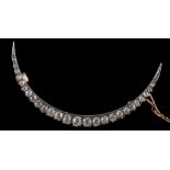 A late 19th century gold and diamond crescent brooch: with graduated round old,
