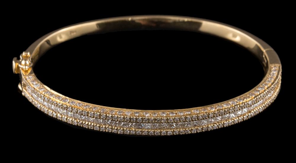 A diamond mounted hinged bangle: with central row of princess-cut diamonds between rows of round