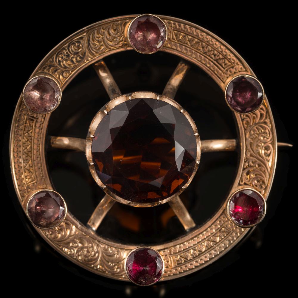 A late 19th century gold Celtic circular brooch: with central round cairngorm approximately 18.