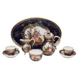 A Meissen blue ground cabaret set: painted with shaped panels of figures in romantic landscape