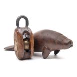 A carved wood figure of a manatee: indistinctly inscribed to the base, 19cm long,