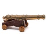 A brass desk model of a cannon: on a Royal Navy style truck, 26cm long.