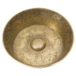 An Islamic engraved brass bowl: with flared sides and central boss to the interior,