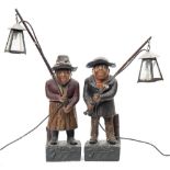 A pair of polychrome painted terracotta figures holding lamps: both wearing broad rim hats and