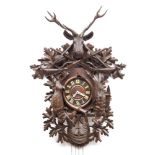 A large carved Black Forest cuckoo wall clock: the eight-day duration weight-driven movement