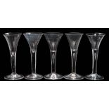 Five wine glasses: each trumpet shaped bowl tapering into a straight stem,