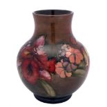 A Moorcroft pottery vase: tubelined in the Orchid and Spring Flowers pattern in red, yellow, green,