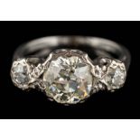 An illusion-set diamond three-stone ring: the principal round old-cut diamond approximately 8.