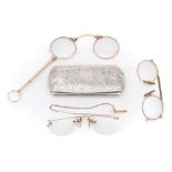 A pair of gilt rimmed spectacles contained in a silver case:,