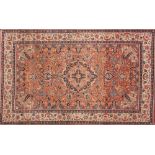 A pair of Kashan rugs:, the brick red fields each with an indigo cartouche pole medallion,