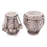 Two Indian white metal pots in the form of drums: having rope tied foliate and scroll decoration,