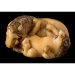 A Japanese ivory netsuke: naturalistically carved as a recumbent horse and foal, Meiji, 3.