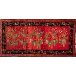 A Turkish rug:, the rose pink field with a row of floral and leaf medallions,